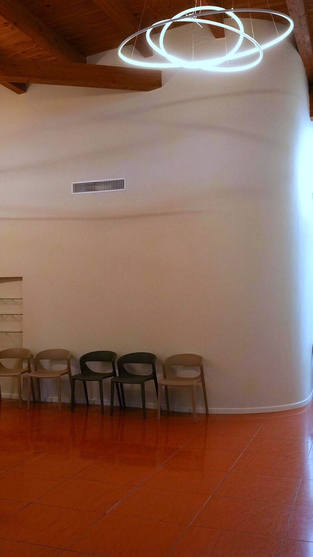 Un angolo della sala d'attesa con la parete curva e il pavimento color terracotta