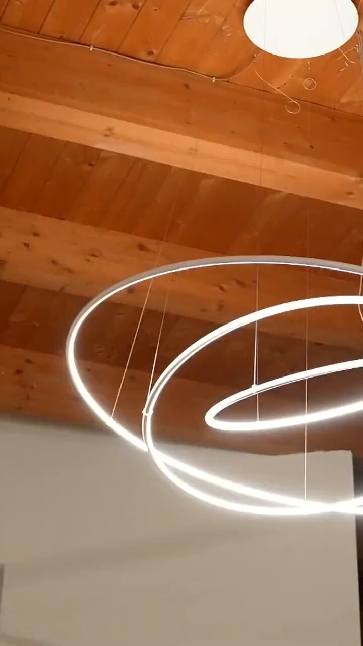Le luci ad anello appese al soffitto in legno della sala d'attesa